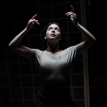 Namiko Gahier-Ogawa, hands raised in a beam of light