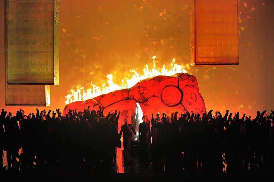 A burning horse above the silhouetted crowd