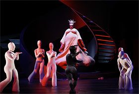 Pale masked dancers around a figure in white